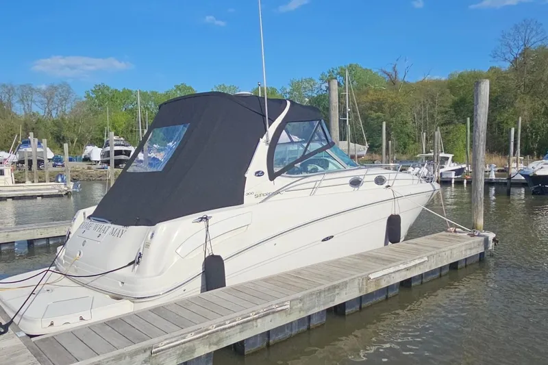 Slide: The Image of 2002 Sea Ray 300 Sundancer docked at marina under clear blue sky. - 2