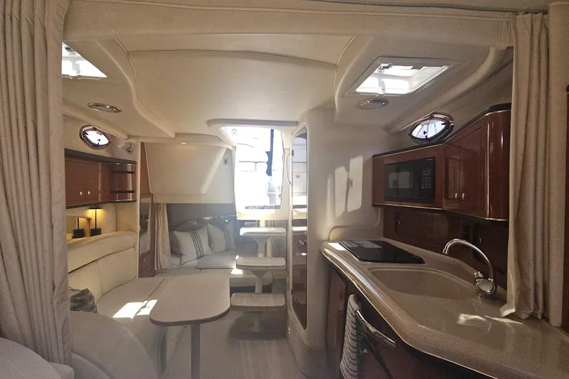 Slide: The Image of Interior of 2002 Sea Ray 300 Sundancer yacht with kitchen and seating area. - 7