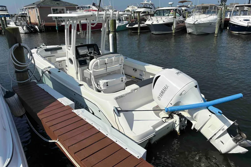 Slide: The Image of 2019 Robalo R242 Explorer boat docked with Yamaha engine in marina. - 2