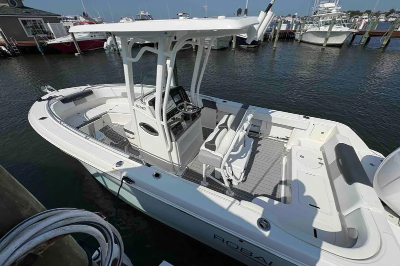 Slide: The Image of 2019 Robalo R242 Explorer boat docked at marina, featuring spacious deck and modern design. - 3