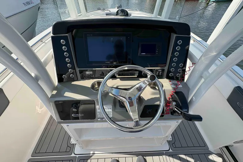 Slide: The Image of 2019 Robalo R242 Explorer boat dashboard with steering wheel and navigation controls. - 5
