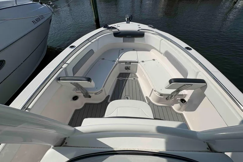 Slide: The Image of 2019 Robalo R242 Explorer boat interior with seating and storage, docked at marina. - 6