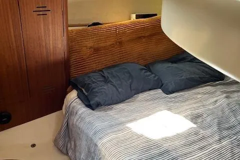 Slide: The Image of Cozy cabin interior of a 1996 Hunter 376 sailboat with striped bedding. - 16