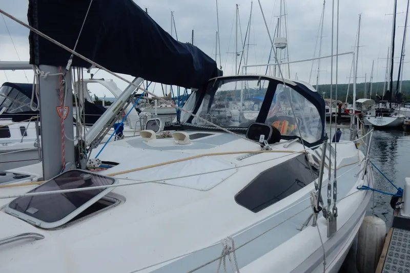 Slide: The Image of 1996 Hunter 376 sailboat docked in a marina, featuring a sleek design and covered cockpit. - 21
