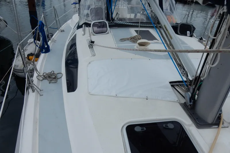 Slide: The Image of 1996 Hunter 376 sailboat deck with rigging and ropes in a marina setting. - 28