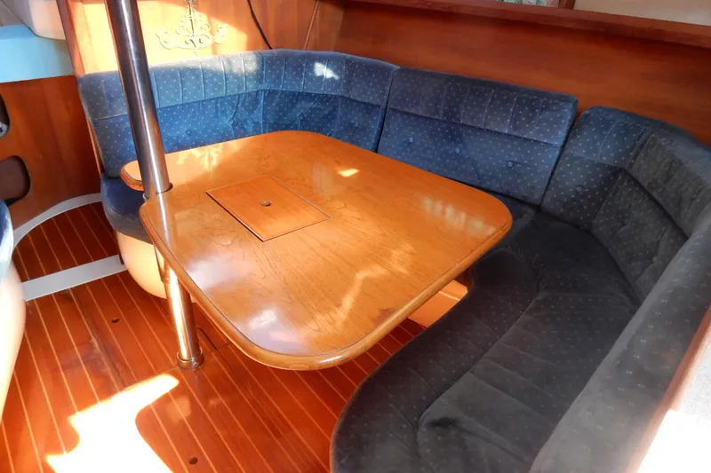 Slide: The Image of Interior of a 1996 Hunter 376 sailboat with wooden table and blue cushioned seating. - 35