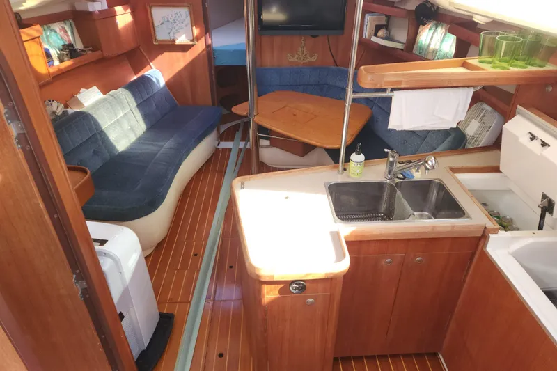 Slide: The Image of Interior of a 1996 Hunter 376 sailboat with cozy seating and kitchenette. - 4