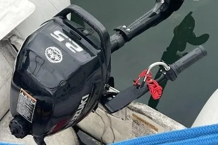 Slide: The Image of Outboard motor on a 1996 Hunter 376 sailboat, docked with visible water reflection. - 45