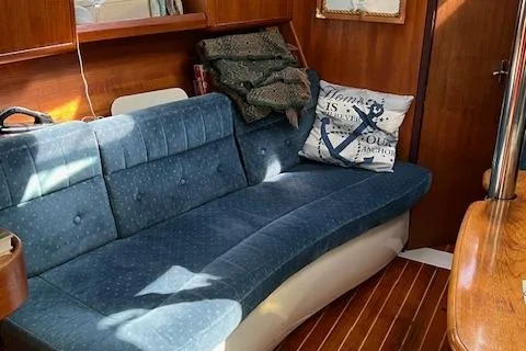 Slide: The Image of Interior of 1996 Hunter 376 sailboat with blue cushioned seating and nautical-themed decor. - 5