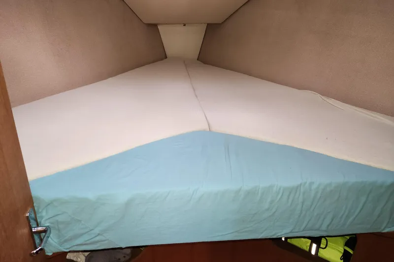 Slide: The Image of V-berth bed in 1996 Hunter 376 sailboat with blue and white bedding. - 8