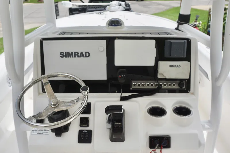 Slide: The Image of 2019 Tidewater 2700 Carolina Bay boat dashboard with Simrad electronics and steering wheel. - 16