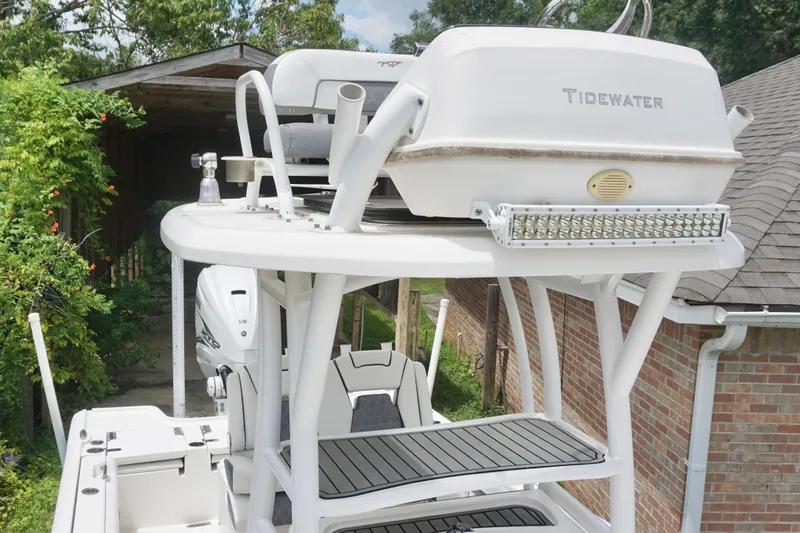Slide: The Image of 2019 Tidewater 2700 Carolina Bay boat with elevated seating and equipment, near a brick building. - 19