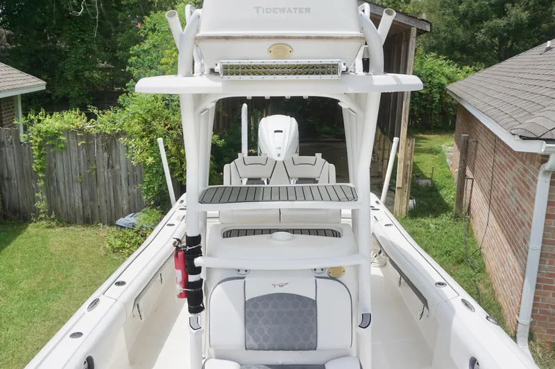 Slide: The Image of 2019 Tidewater 2700 Carolina Bay boat, white interior, outdoor setting, surrounded by greenery. - 20