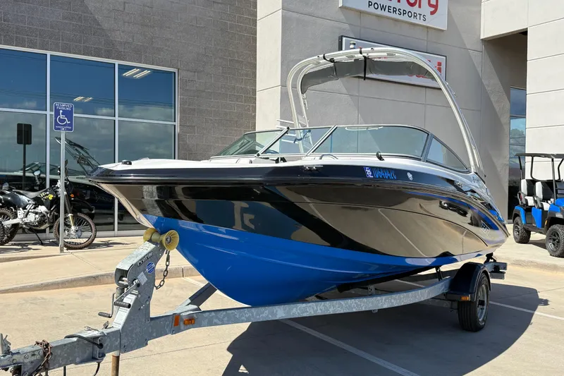 The Image of 2017 Yamaha AR190 boat on trailer outside dealership, showcasing sleek design and vibrant blue hull. - 0