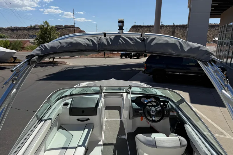 Slide: The Image of 2017 Yamaha AR190 boat interior with steering wheel and seating, parked outdoors. - 23