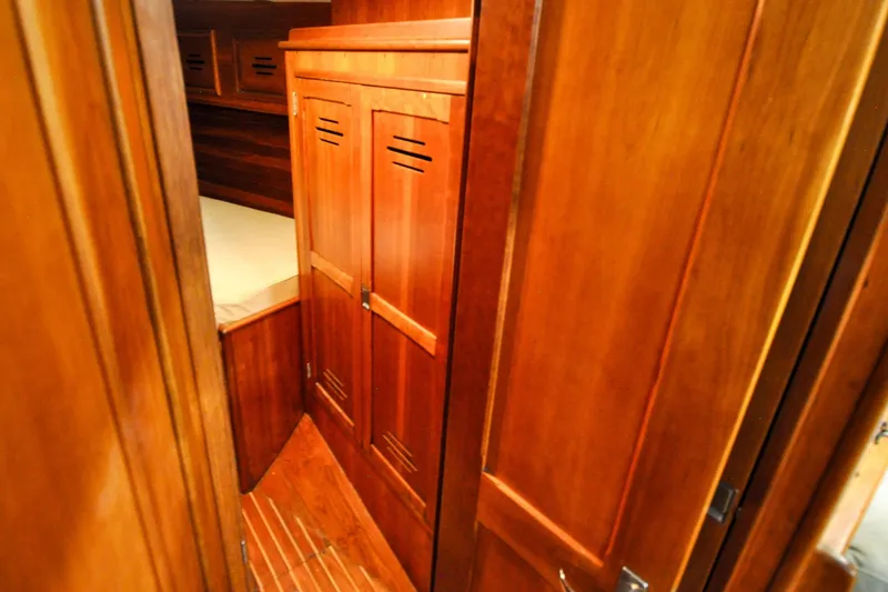 Slide: The Image of Hinckley Sou'wester 51 yacht interior, 1986, featuring wooden cabinetry and cozy sleeping quarters. - 106