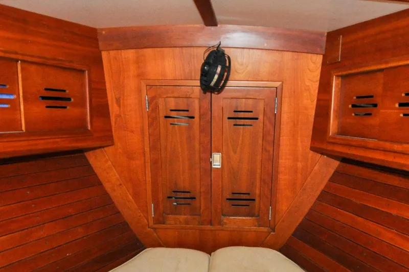 Slide: The Image of Interior of 1986 Hinckley Sou'wester 51 sailboat with wooden cabinetry and cozy berth. - 110