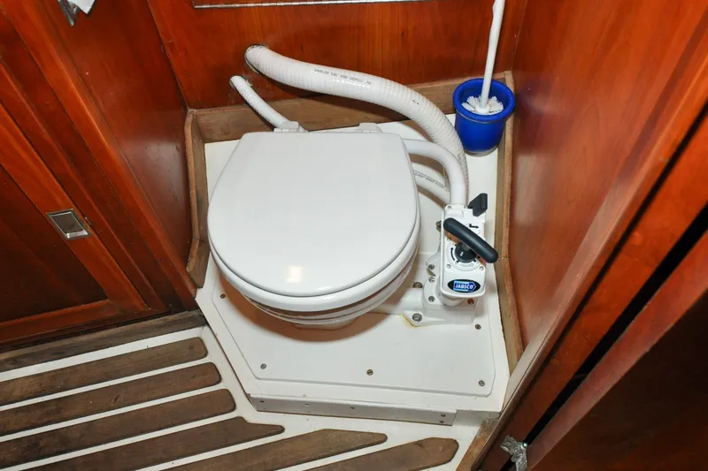 Slide: The Image of Hinckley Sou'wester 51 yacht bathroom with marine toilet, wooden paneling, and floor, 1986 model. - 115