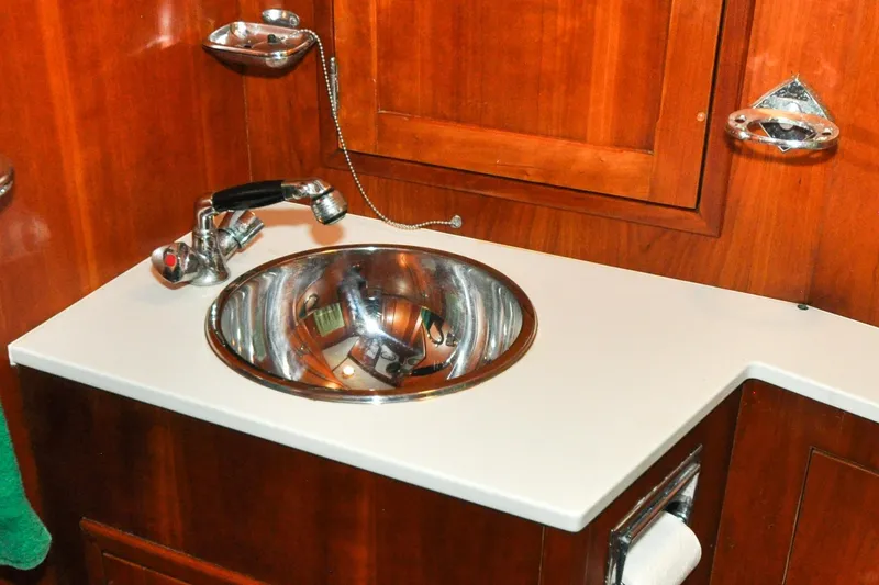 Slide: The Image of Stainless steel sink in 1986 Hinckley Sou'wester 51 yacht bathroom with wooden cabinetry. - 117