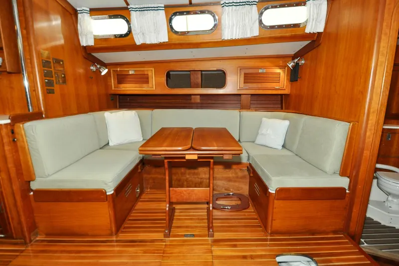 Slide: The Image of Interior of 1986 Hinckley Sou'wester 51 sailboat with wooden dining area and cushioned seating. - 120