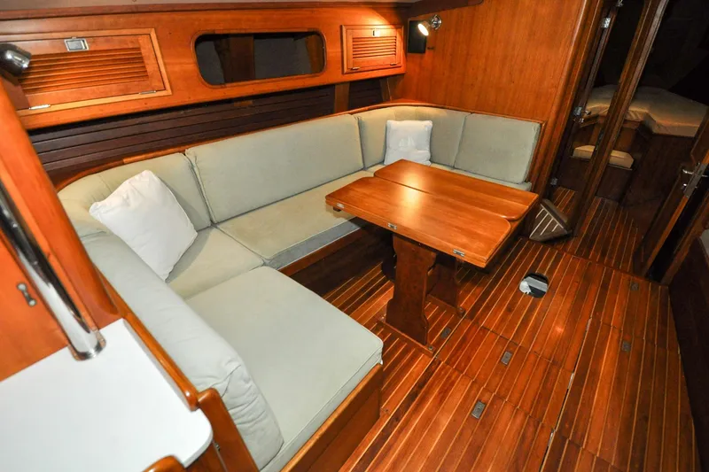 Slide: The Image of 1986 Hinckley Sou'wester 51 yacht interior with wooden flooring and cozy seating area. - 122
