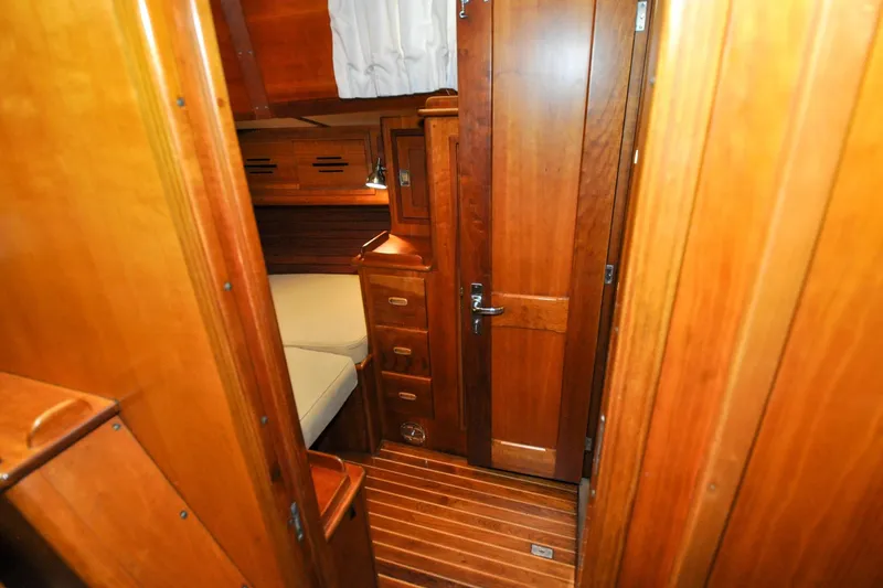 Slide: The Image of Interior of 1986 Hinckley Sou'wester 51 sailboat with wooden cabinetry and cozy sleeping area. - 127