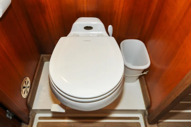 Slide: The Image of Hinckley Sou'wester 51 yacht bathroom with white toilet and wooden paneling, 1986 model. - 134