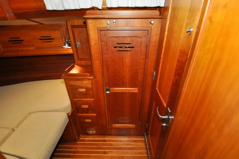 Slide: The Image of Hinckley Sou'wester 51 (1986) interior with wooden cabinetry and cozy sleeping area. - 136