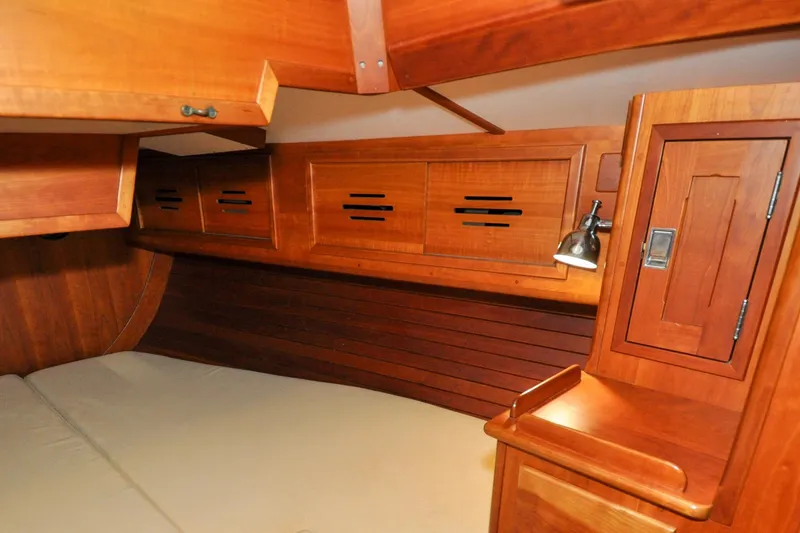 Slide: The Image of Interior of 1986 Hinckley Sou'wester 51 sailboat with wooden cabinetry and cozy sleeping area. - 137