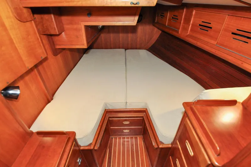 Slide: The Image of Hinckley Sou'wester 51 (1986) cabin interior with wooden finish and cozy bedding. - 138