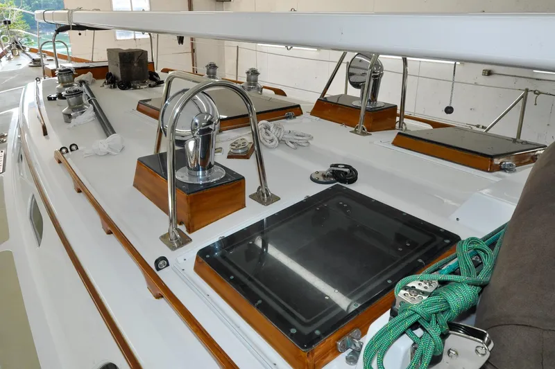 Slide: The Image of 1986 Hinckley Sou'wester 51 sailboat deck with winches and ropes in a marina. - 57