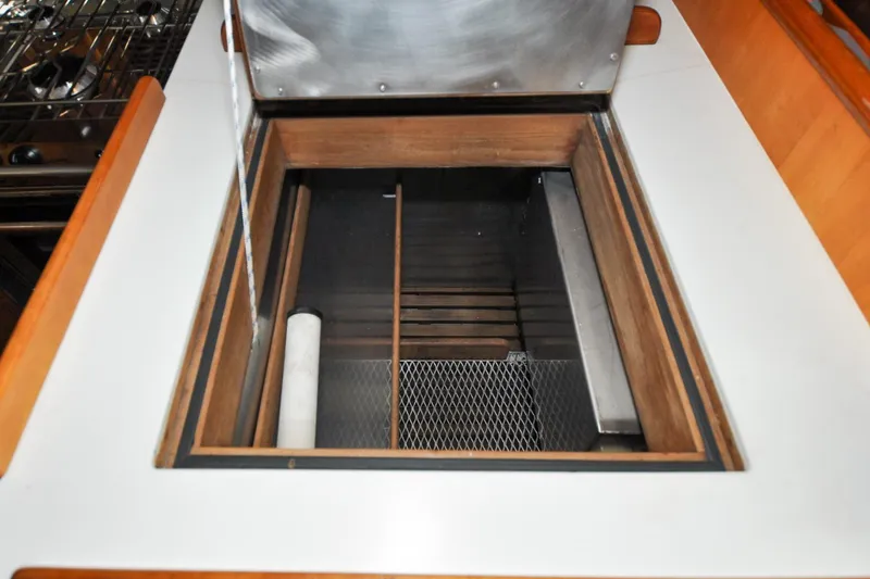 Slide: The Image of Open storage compartment on 1986 Hinckley Sou'wester 51 yacht, featuring wooden and metal elements. - 89