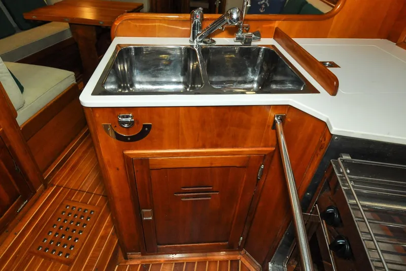 Slide: The Image of Hinckley Sou'wester 51 yacht kitchen with wooden cabinetry and stainless steel sink, 1986 model. - 97