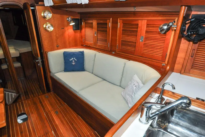Slide: The Image of Interior of 1986 Hinckley Sou'wester 51 yacht with wooden finish and cozy seating area. - 99