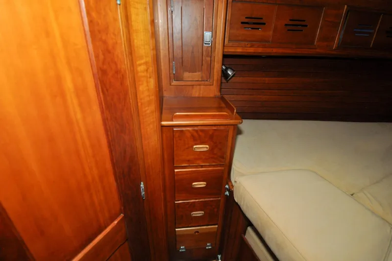 Slide: The Image of Hinckley Sou'wester 51 yacht interior, 1986, featuring wooden cabinetry and cozy sleeping area. - 112