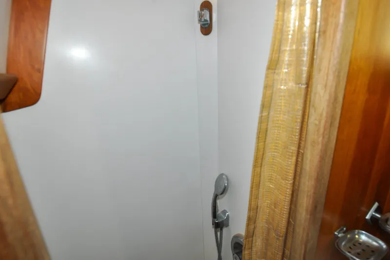 Slide: The Image of Shower area in 1986 Hinckley Sou'wester 51 yacht with wooden accents and curtain. - 131