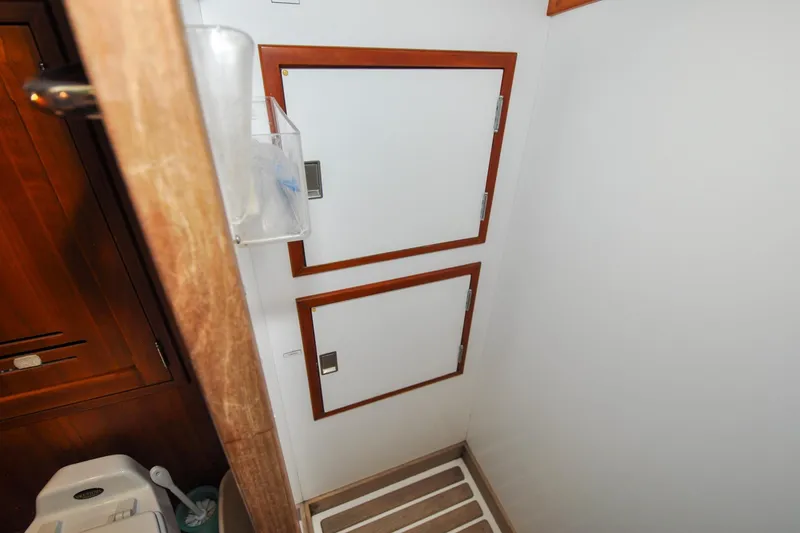 Slide: The Image of Interior of 1986 Hinckley Sou'wester 51 yacht, featuring wooden cabinetry and storage compartments. - 132