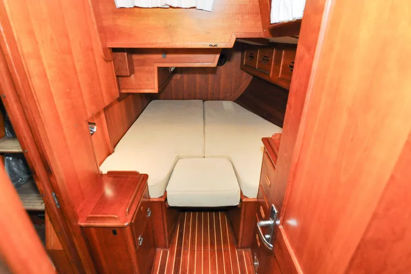 Slide: The Image of Hinckley Sou'wester 51 (1986) cabin interior with wooden finish and cozy bed. - 135