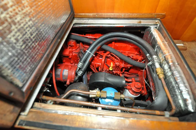 Slide: The Image of Engine compartment of a 1986 Hinckley Sou'wester 51 sailboat, featuring red engine components. - 143