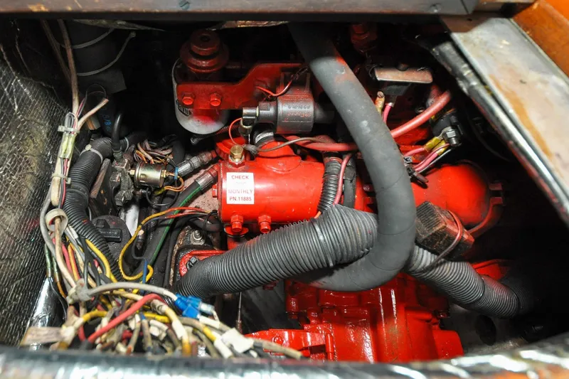 Slide: The Image of Engine compartment of a 1986 Hinckley Sou'wester 51 sailboat, featuring red components and wiring. - 144