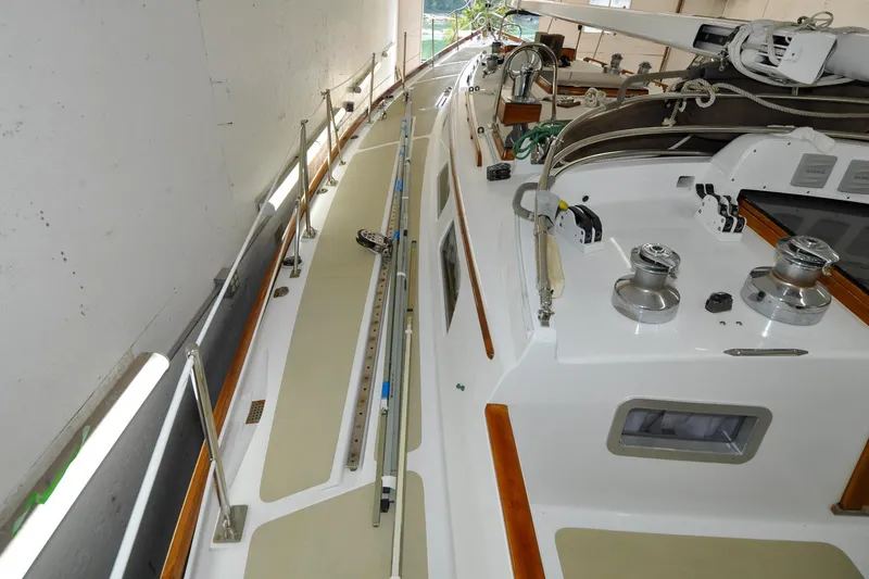 Slide: The Image of 1986 Hinckley Sou'wester 51 sailboat deck with winches and rigging in a storage facility. - 54