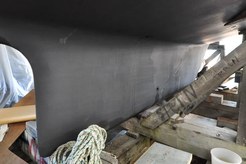 Slide: The Image of 1986 Hinckley Sou'wester 51 yacht keel in dry dock, supported by wooden beams. - 6