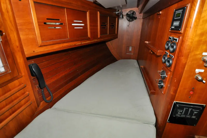 Slide: The Image of 1986 Hinckley Sou'wester 51 yacht interior with wooden cabinetry and control panels. - 75