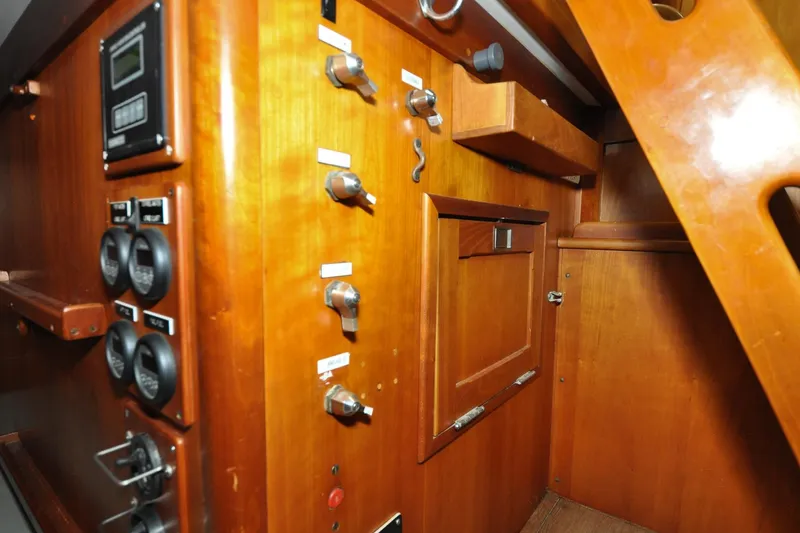 Slide: The Image of Interior of 1986 Hinckley Sou'wester 51 yacht, featuring wooden cabinetry and control panels. - 77