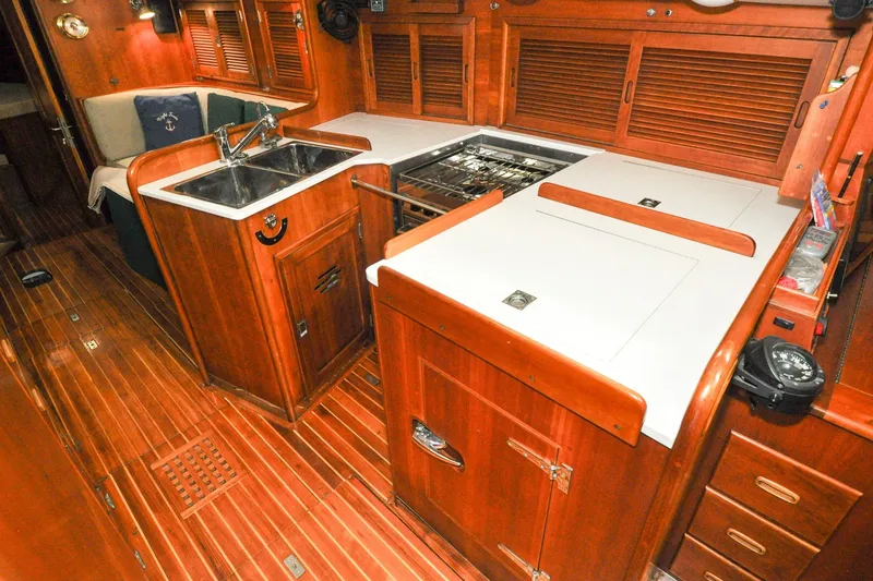 Slide: The Image of Interior of 1986 Hinckley Sou'wester 51 yacht, featuring a wooden galley with sink and stove. - 88