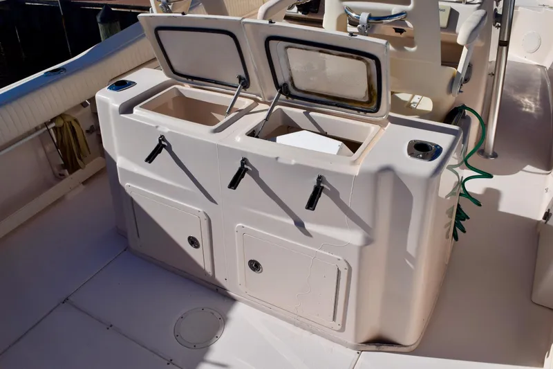 Slide: The Image of 2006 Grady-White Bimini 306 boat interior with open storage compartments and seating. - 11