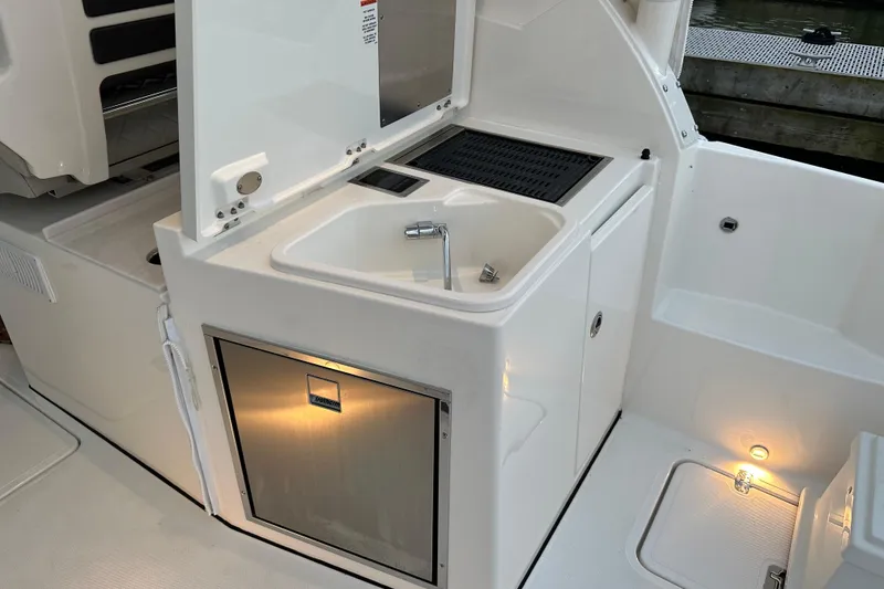 Slide: The Image of 2023 Pursuit DC 326 Dual Console boat on calm water at sunset. - 12