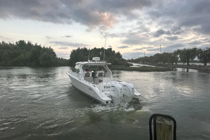 Slide: The Image of 2023 Pursuit DC 326 Dual Console boat docked, featuring radar and rod holders. - 28