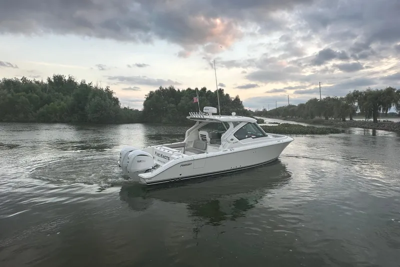 Slide: The Image of 2023 Pursuit DC 326 Dual Console boat with twin outboard engines and illuminated water. - 30