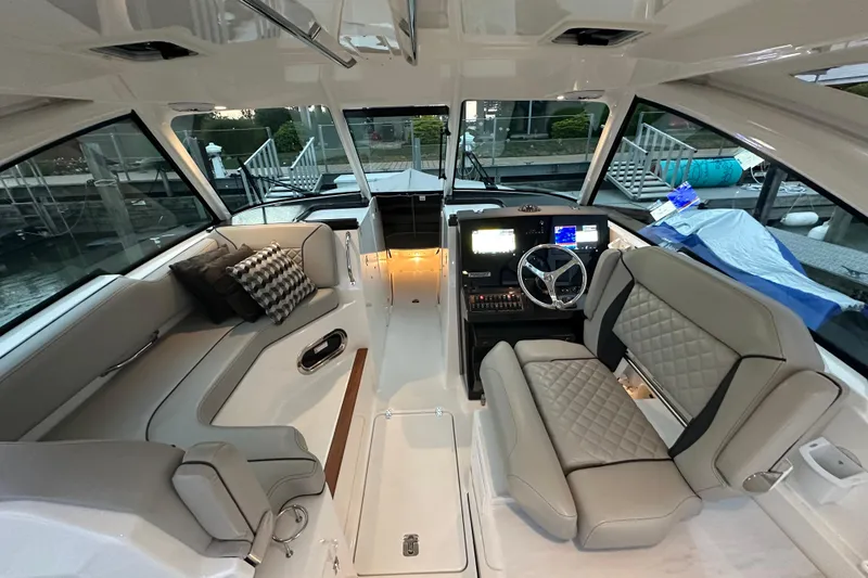 Slide: The Image of 2023 Pursuit DC 326 Dual Console boat cruising on calm water at sunset. - 4